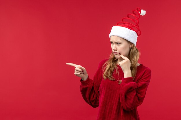 Mujer joven de vista frontal con expresión triste, rojo de vacaciones de Navidad