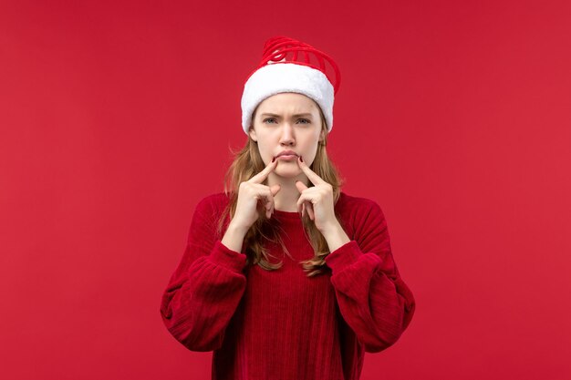 Mujer joven de vista frontal con expresión triste, rojo de vacaciones de Navidad