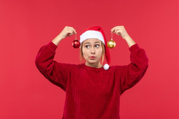 Mujer joven de vista frontal con juguetes de navidad, emociones de vacaciones de navidad