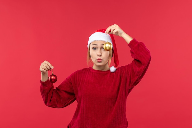 Mujer joven de vista frontal con juguetes de navidad, vacaciones de emociones de navidad