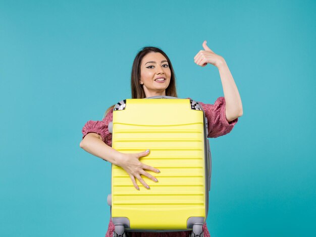 Mujer joven de vista frontal que va de vacaciones y que sostiene una bolsa grande en el fondo azul viaje de verano viaje de vacaciones en el mar mujer