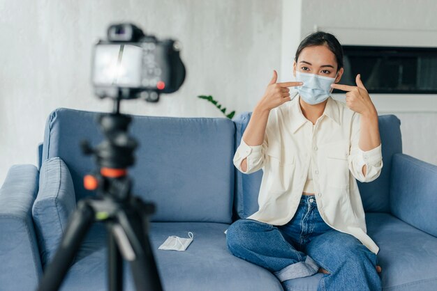 Foto gratuita mujer joven vlogging sobre máscaras médicas