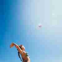 Foto gratuita mujer jugando al voleibol de playa con sol de fondo