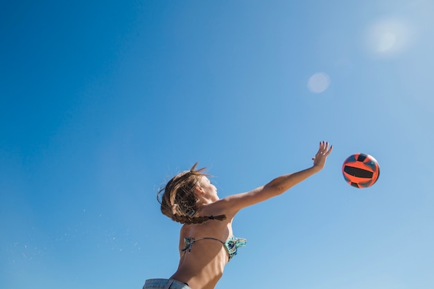 Mujer jugando al voleibol de playa vista de abajo