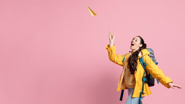 Mujer jugando con un avión de papel con espacio de copia