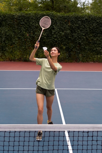 Mujer jugando bádminton tiro completo