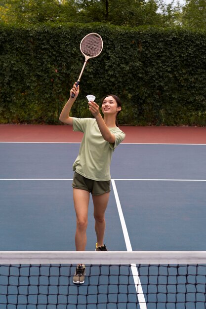 Mujer jugando bádminton tiro completo