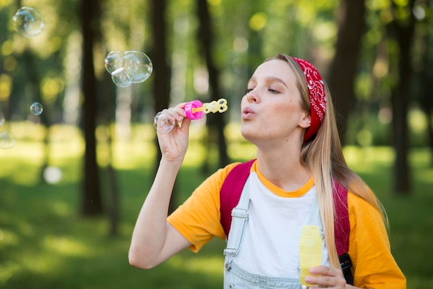 Foto gratuita mujer jugando con burbujas al aire libre