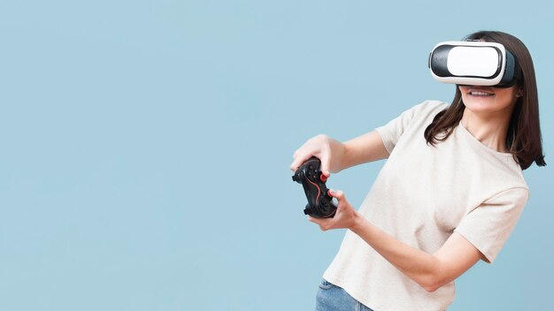 Mujer jugando con casco de realidad virtual y control remoto