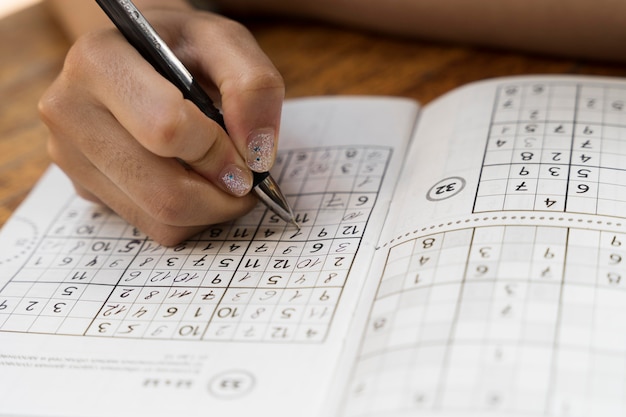 Mujer jugando un juego de sudoku sola