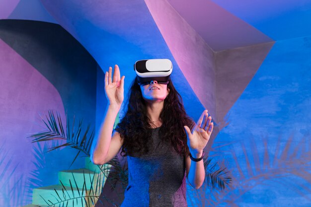 Mujer jugando juegos en vr set en interiores