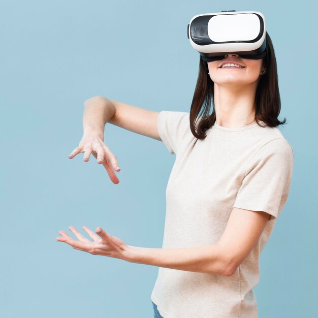 Mujer jugando mientras usa casco de realidad virtual