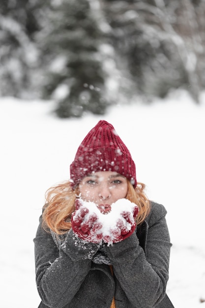 Foto gratuita mujer jugando con nieve al aire libre