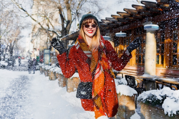 Mujer jugando con nieve, divirtiéndose y disfrutando de las vacaciones