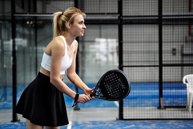 Mujer jugando padel tiro medio