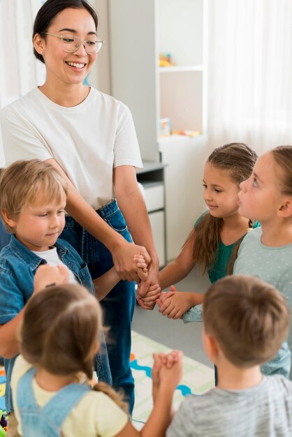 Mujer jugando con sus alumnos en el interior