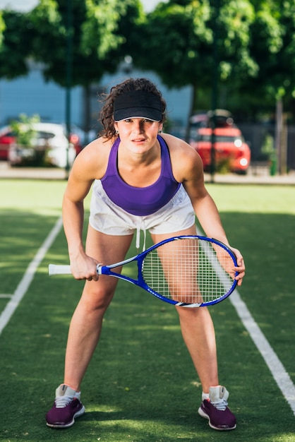 Mujer jugando tenis y esperando el servicio