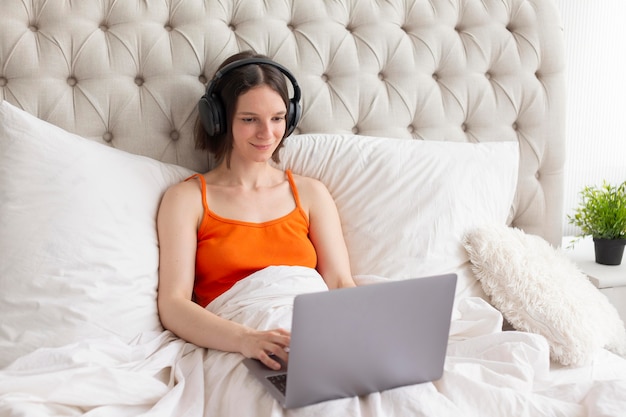 Mujer jugando videojuegos en la cama