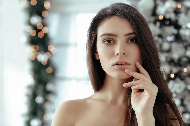 Mujer junto al árbol de Navidad