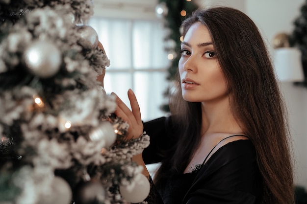 Mujer junto al árbol de Navidad