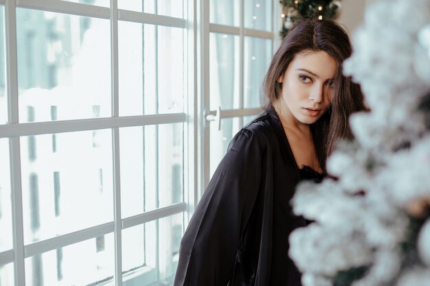 Mujer junto al árbol de Navidad