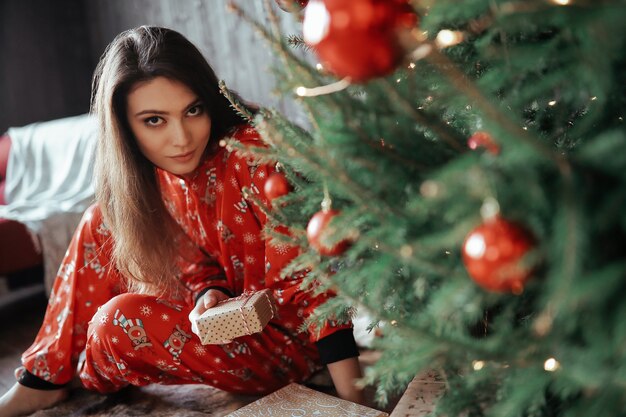 Mujer junto al árbol de Navidad