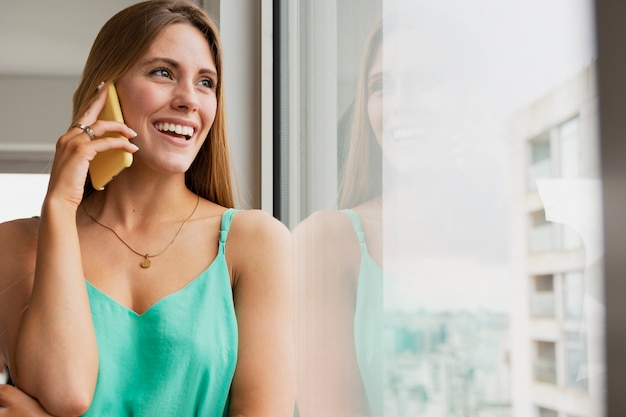 Mujer junto al espejo hablando por teléfono