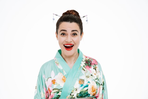 Mujer en kimono japonés tradicional asombrado y sorprendido en blanco