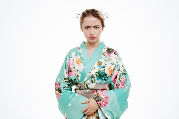 Mujer en kimono japonés tradicional con cara enojada frunciendo el ceño en blanco