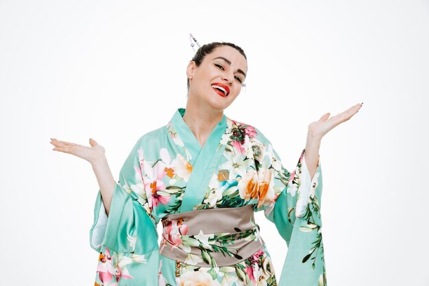 Mujer en kimono japonés tradicional feliz y complacido levantando los brazos sonriendo ampliamente en blanco