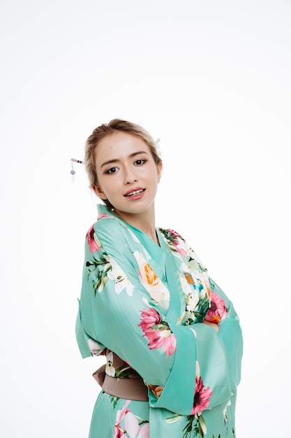 Mujer en kimono japonés tradicional feliz y positivo sonriendo confiado en blanco