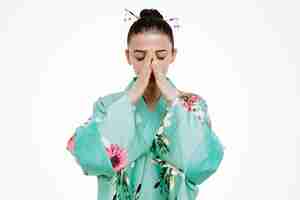 Foto gratuita mujer en kimono japonés tradicional mirando triste celebración hads juntos en blanco