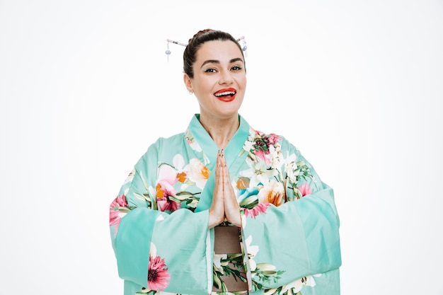 Foto gratuita mujer en kimono japonés tradicional sonriendo tomados de la mano juntos en gesto de saludo en blanco