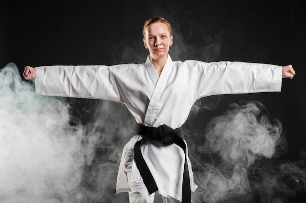 Mujer en kimono practicando taekwondo