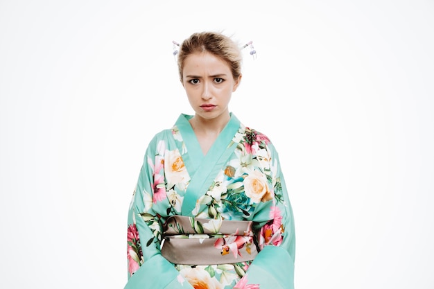 Mujer en kimono tradicional japonés con cara enojada con el ceño fruncido en blanco