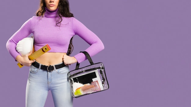 Mujer con kit de maquillaje y kit de construcción copia espacio