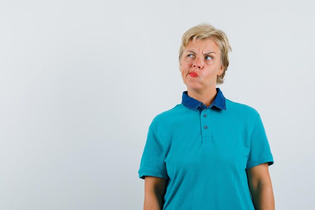 Mujer con labios fruncidos sobre fondo blanco.