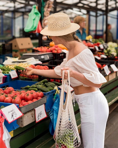 Mujer de lado con bolsa orgánica para verduras