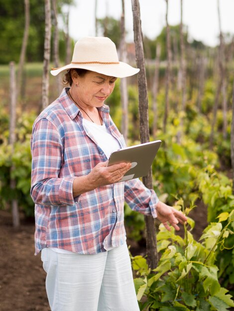 Mujer de lado comprobando su jardín