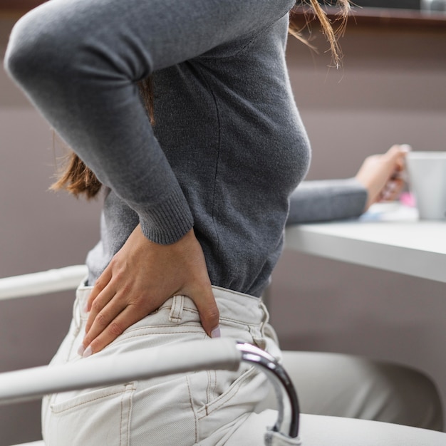 Foto gratuita mujer de lado con dolor de espalda mientras trabaja desde casa