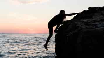 Foto gratuita mujer de lado escalada sobre una roca