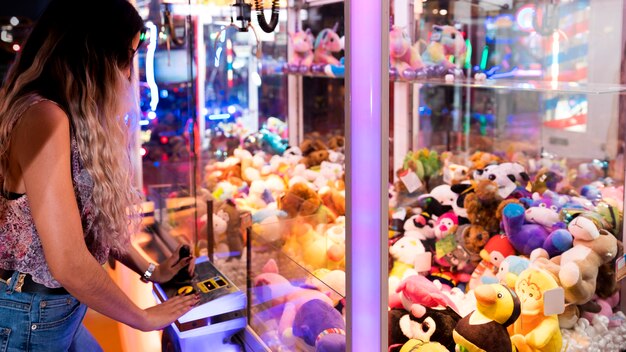 Mujer de lado jugando máquina arcade
