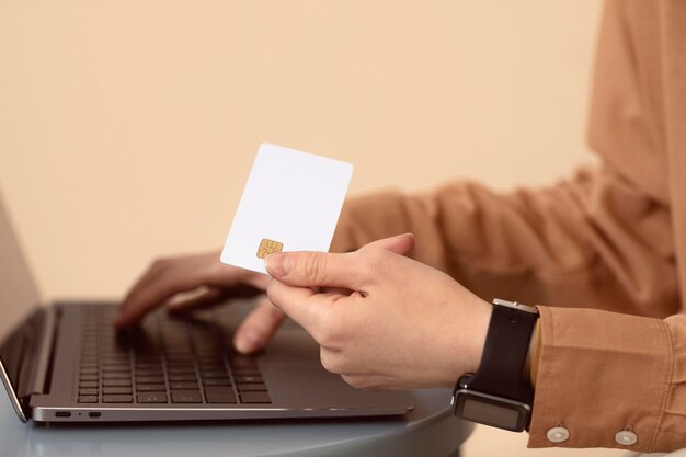 Mujer de lado con laptop y tarjeta comercial