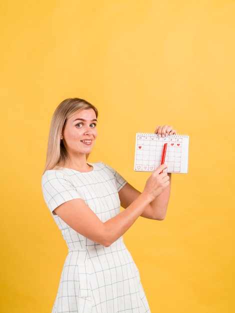 Mujer de lado mostrando su calendario de períodos