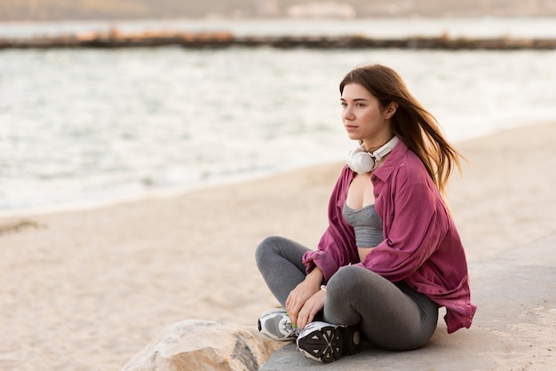 Mujer de lado relajándose en la playa con espacio de copia