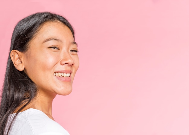 Mujer de lado sonriendo a la cámara