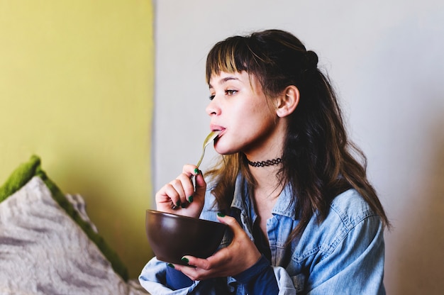 Mujer lamiendo cuchara y comer