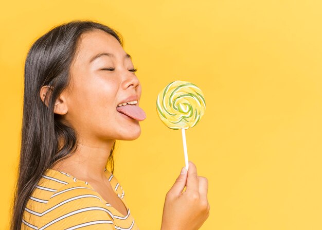 Mujer lamiendo una paleta de lado