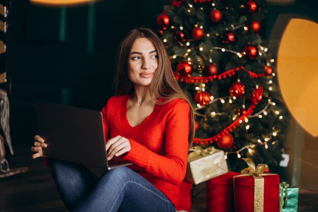 Mujer con laptop con árbol de navidad