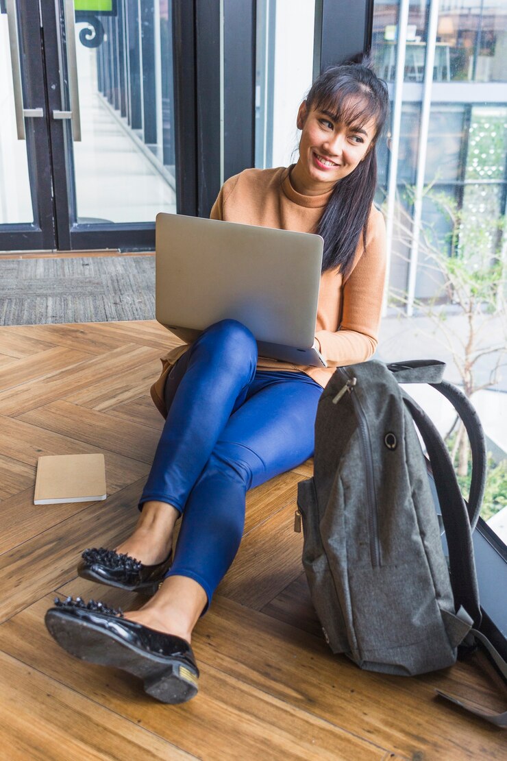 Foto gratuito mujer con laptop cerca de mochila